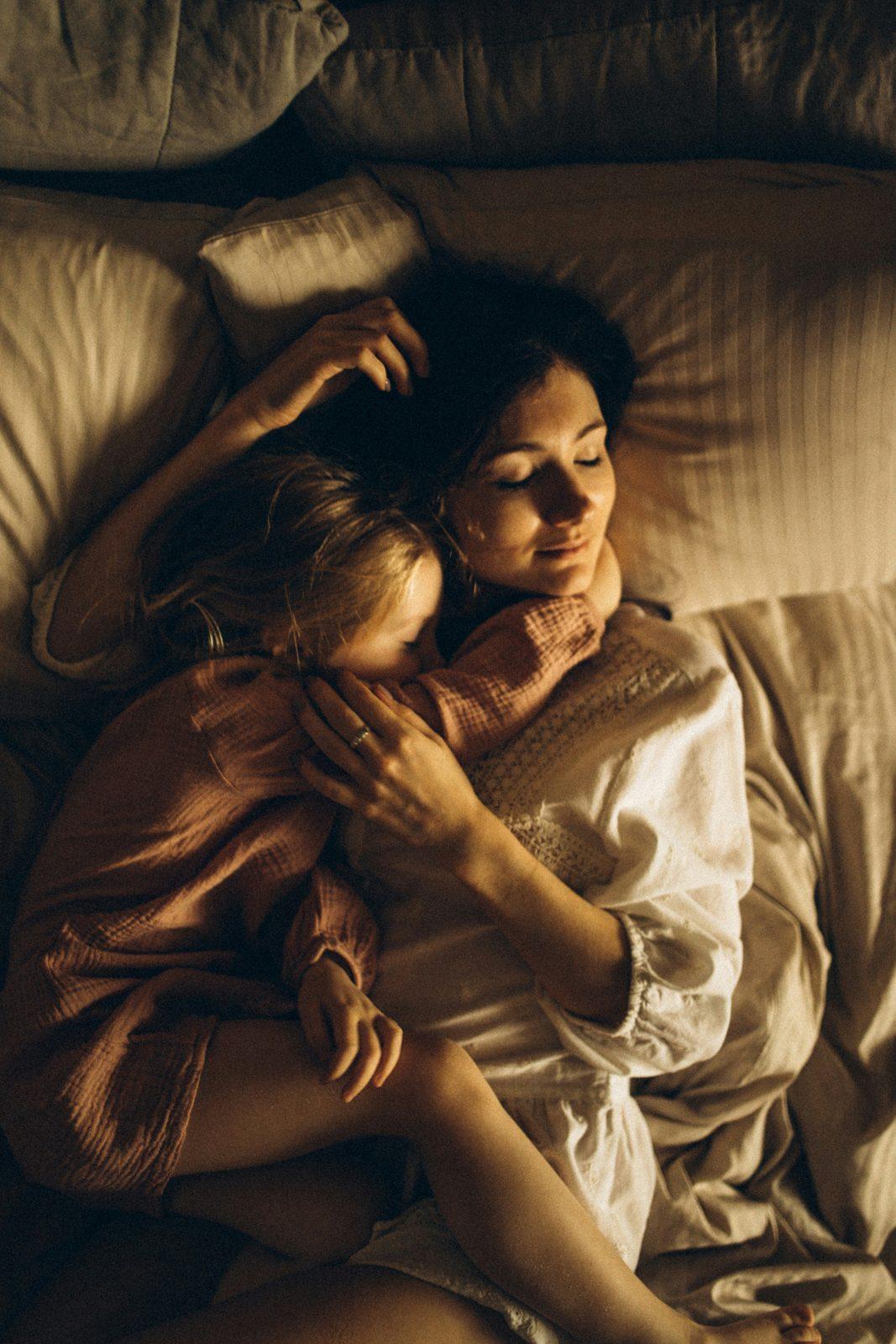 Câlin tendre parent-enfant au coucher, lumière chaude